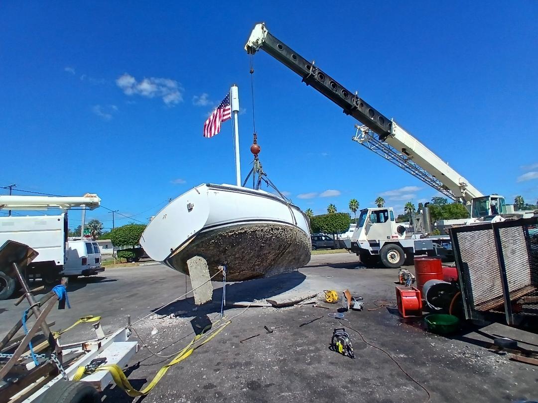 Sailboat being lifted by crane for removal